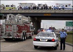 Firefighters from Nassau Bay, Webster Forest Bend League City Fire Departments, Nassau Bay EMS and HPD Police Officer lined the NASA Bridge over Interstate 45 as fallen firefighter Capt. Grady Burke, 39, passes under on the way to the funeral home in Webster, Texas, Sunday, 20, 2005.