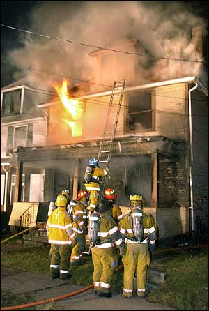 Flames shoot out of the second floor of a single-family home in Tarentum, Pa., early Tuesday, Feb 22, 2005, as firefighters work to contain the fire. Two adults and a teenager were killed in the blaze, fire officials said.