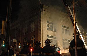 Knoxville Fire Department firefighters gather outside the Crimson building as smoke billows from the building in Knoxville, Tenn., Sunday, Feb. 27, 2005.