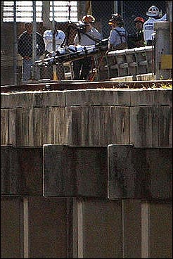 Miami-Dade firefighters rescue a man Wednesday, March 2, 2005, who fell off the lower bridge at the Port of Miami Sunday night. The unidentified man, described as in his 20s, was in serious but stable condition at Jackson Memorial Hospital after rescuers used ropes to hoist his stretcher up to the foot of the railroad's drawbridge, said Miami-Dade Fire Rescue spokesman Capt. Louie Fernandez.