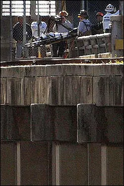 Miami-Dade firefighters rescue a man Wednesday, March 2, 2005, who fell off the lower bridge at the Port of Miami Sunday night. The unidentified man, described as in his 20s, was in serious but stable condition at Jackson Memorial Hospital after rescuers used ropes to hoist his stretcher up to the foot of the railroad's drawbridge, said Miami-Dade Fire Rescue spokesman Capt. Louie Fernandez.