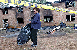 Mai Cuc Do retrieves some of her belongings from her apartment, which was destroyed by fire early Thursday morning, March 3, 2005, in Clarkston, Ga. The fire at the two-story apartment building killed three people, all of whom are believed to be family members. At least two others were injured in the blaze Wednesday night at Cherokee Woods Apartments.