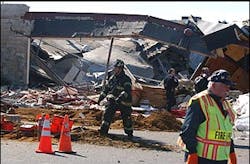 A firefighter walks past the collapsed roof of the PETCO store Friday, March 4, 2005, in Eatontown, N.J., after a damaged gas line exploded, trapping at least four people and scores of animals in the rubble, authorities said.