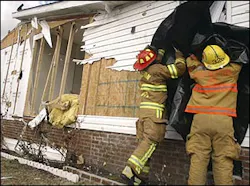 Stansburg volunteer firefighters cover a broken window after several mobile homes received damage from strong winds in Wilson, N.C., Tuesday, March 8, 2005. No one was injured but several people have been evacuated to area hotels as officials deemed their homes unsuitable for habitation.