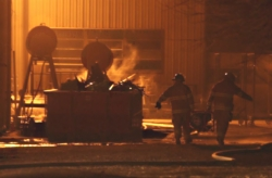 Firefighters head toward a smoke-filled building at the Lift-A-Loft plant at 9501 S. Center Road in Cowan.