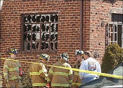 NJ FATAL FIREFirefighters stand next to a brick home in Teaneck, N.J., where a fire early Tuesday, March 22, 2005, killed four children and critically injured their mother.