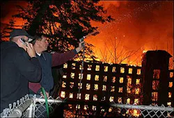 MILL FIRE: A man who identified himself only as an off duty Providence firefighter sprays water on a house across from a vacant mill fire in West Warwick, R.I. on Wednesday, March 30, 2005. The mill building had been vacant for several years and was slated to be renovated as condominiums or apartments.(AP Photo/Joe Giblin) MILL FIRE: A man who identified himself only as an off duty Providence firefighter sprays water on a house across from a vacant mill fire in West Warwick, R.I. on Wednesday, March 30, 2005. The mill building had been vacant for several years and was slated to be renovated as condominiums or apartments.(AP Photo/Joe Giblin)