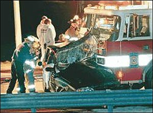 Rescue personnel examine the car that was struck early Wednesday morning.