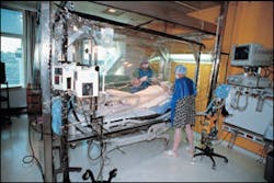Two nurses assigned to the Acute Floor tend to a patient in the Bacterial Control Bursing Unit, which cares for children with large-percent burn injuries. Two nurses assigned to the Acute Floor tend to a patient in the Bacterial Control Bursing Unit, which cares for children with large-percent burn injuries.