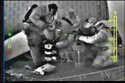 The TI can help a RIT officer supervise the removal of a trapped firefighter. Here, the officer can see that the fire to the left is significantly heating the rescuers. One rescuer is not only standing, but is missing his helmet.