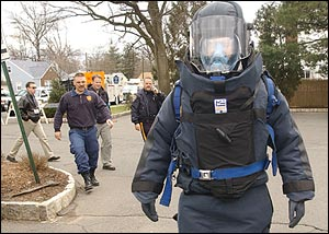 A member of the Union County, N.J., bomb squad in full protective gear walks through a parking lot at Kean University in Hillside, N.J., during a mock disaster drill.