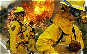 Firefighters with the California Department of Forestry, set backfires along highway 79, in this May 3, 2004, file photo taken near Temecula, Calif. Fighting California's wildfires has developed into a multi-agency effort but dividing up responsibility and costs can quickly spiral to more than $1 million a day, the Legislative Analyst's Office said Tuesday April 12, 2005. (AP Photo/Ric Francis, File)