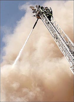 Virginia firefighters direct a high pressure foam spray onto a blazing department store from an aerial truck Thursday, April 14, 2005, in Virginia, Minn. The fire completely destroyed the business. (AP Photo/Mesabi Daily News, Mark Sauer)