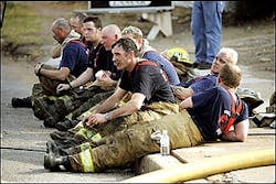 Oklahoma City Firefighters take a break after battling an abandon tire warehouse fire in Oklahoma City. The three alarm blaze created heavy smoke. (AP Photo/The Oklahoman, Steve Gooch)