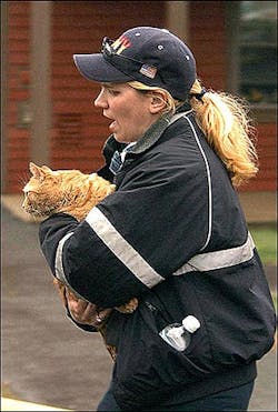 Emergency Medical Technician Wanda Goodwin of the Townsend, Mass. fire department carries a cat from a multiple-alarm fire at a senior housing complex in Pepperell, Wednesday, April 27, 2005. Residents at the 51-unit Babbitassett Village were evacuated from the scene during the fire. (AP Photo/John Sotiriou)