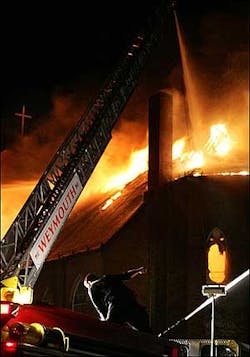 A Weymouth, Mass., firefighter directs a hose during a fire which destroyed Sacred Heart Church in Weymouth on Friday morning, June 10, 2005.