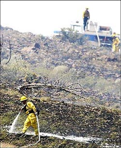 Nevada Department of Forestry workers check on hot spots, Thursday, June 16, 2005, south of Virginia City, Nev.