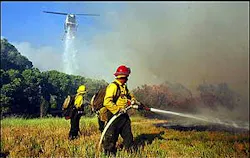 A helicopter makes a water drop on a fire in Morongo Valley, Calif., Wednesday, June 22, 2005, as U.S. Forest Service firefighters work the fire from the ground. The fire has burned at least seven homes. A helicopter makes a water drop on a fire in Morongo Valley, Calif., Wednesday, June 22, 2005, as U.S. Forest Service firefighters work the fire from the ground. The fire has burned at least seven homes.