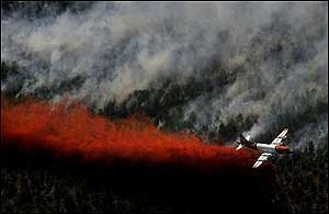 An airplane dumps fire retardant onto the eastern edge of the Blue Springs fire, Sunday, June 26, 2005, near Toquerville, Utah.