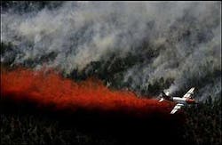 An airplane dumps fire retardant onto the eastern edge of the Blue Springs fire, Sunday, June 26, 2005, near Toquerville, Utah.