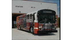 The newly wrapped city bus in front of the new Greensboro Fire Department Station 11.