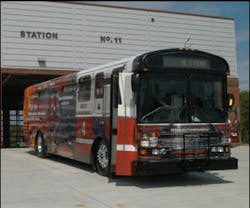 The newly wrapped city bus in front of the new Greensboro Fire Department Station 11.