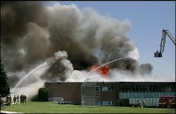 Firefighters spray water on Wasatch Junior High School as it burns in Salt Lake City, Monday, July 11, 2005. A six-alarm fire Monday destroyed the school, leaving officials scrambling to place 850 students for the fall term that starts in less than seven weeks.