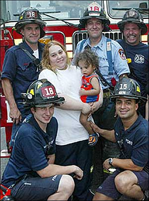 HEARTFELT THANKS: Delores Cuebas, with year-old son Frederick, yesterday salutes rescuers from Ladder Co. 18 and Engine Co. 15.