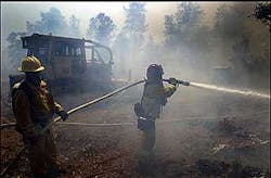 City of Redding firefighter Mike Lowrey, left, and Capt. Ed Andrews cool off the left flank of a fire the burned about 34 acres on Monday, July 25, 2005, in Redding, Calif. Dozens of houses where threatend in the area of Gold Hills Golf Club. No structures were burned and the fire was contained by midafternoon. City of Redding firefighter Mike Lowrey, left, and Capt. Ed Andrews cool off the left flank of a fire the burned about 34 acres on Monday, July 25, 2005, in Redding, Calif. Dozens of houses where threatend in the area of Gold Hills Golf Club. No structures were burned and the fire was contained by midafternoon.