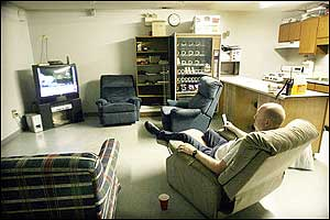 Columbia, S.C. Firefighter James Ballentine works his 24 hour shift alone at the Capital View Fire Station, July 24, 2005. After inspecting the trucks and equipment Ballentine spends some of his down time watching television.