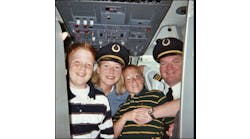 Selena and Glen Schmidt and their sons Trevin and Justin during a visit to Glen&rsquo;s &ldquo;workplace&rdquo; in an Air Train Airways cockpit.