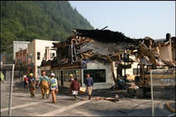 The morning after the fire, firefighters and a building inspector check the grounds and escort tenants to recover valuables and survey the damage.