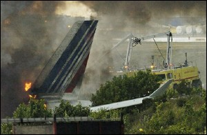 Emergency crews work to extinguish a fire on an Air France plane which ran off the runway while landing at Pearson International Airport in Toronto Tuesday August 2, 2005.
