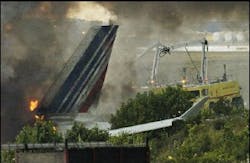 Emergency crews work to extinguish a fire on an Air France plane which ran off the runway while landing at Pearson International Airport in Toronto Tuesday August 2, 2005.