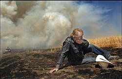 Dion Hagen covers his face as he is overcome by smoke and heat while fighting wheat field fire east of Dutton, Mont., Thursday, Aug. 4, 2005. Hagan is among the many neighbors and nearby landowners who responded with their farming equipment to help battle the blaze.