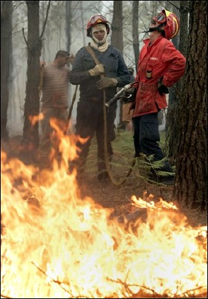 Exhausted Firefighters and volunteers fight a fire Friday, Aug. 5, 2005, near Leiria some 150 kilometers (90 miles) north of Lisbon. Some 2,900 firefighters, supported by about 900 vehicles, were on duty Friday fighting forest fires in northern and central Portugal.