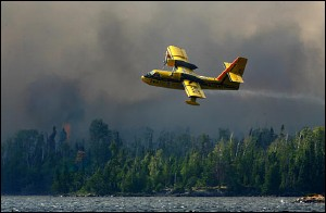 A tanker lifts off Sea Gull Lake in the Boundary Waters Canoe Area Wilderness, Monday afternoon, Aug 8, 2005, after picking up a tank of water from the lake to fight the Forest fire between Alpine and Sea Gull Lake, Minn. Drizzle helped firefighters Tuesday as they worked to contain the wildfire that has grown to about 690 acres.