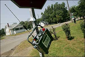 An EPA air monitoring device hangs from a stop sign at the intersection of Avalon Road and Wayne Road near the E.Q. Resource Recovery Inc. plant in Romulus, Mich., Wednesday, Aug. 10, 2005. The facility recycles chemicals such as airplane deicing fluid and industrial paint solvents.