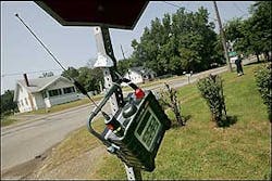 An EPA air monitoring device hangs from a stop sign at the intersection of Avalon Road and Wayne Road near the E.Q. Resource Recovery Inc. plant in Romulus, Mich., Wednesday, Aug. 10, 2005. The facility recycles chemicals such as airplane deicing fluid and industrial paint solvents.