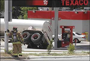 Firefighters contain thousands of gallons of unleaded gasoline spilled when a tank trailer tipped over at a gas station in Fort Worth, Texas, Wednesday, Aug. 17, 2005. The gasoline did not ignite, and run-off gasoline was contained in a creek a few blocks south. Firefighters planned to use a vacuum truck to remove the liquid. Streets for several blocks were blocked off as a safety precaution.