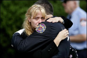 A mourner at the funeral services for U.S. Army Spc. John N. Kulick is comforted by one of Kulick's firefighter colleagues during funeral services in Hatboro, Pa., Thursday, Aug. 18, 2005.
