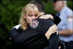 A mourner at the funeral services for U.S. Army Spc. John N. Kulick is comforted by one of Kulick's firefighter colleagues during funeral services in Hatboro, Pa., Thursday, Aug. 18, 2005. A mourner at the funeral services for U.S. Army Spc. John N. Kulick is comforted by one of Kulick's firefighter colleagues during funeral services in Hatboro, Pa., Thursday, Aug. 18, 2005.