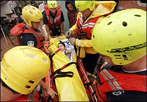 Rural Metro firefighters prepare to evacuate Joseph Kogel, 18, from the mobile home where he lives with his family Aug. 7, 2005, in Tucson, Ariz. Storms dumped up to 4 inches of rain Tuesday, Aug. 23, 2005, across southern Arizona, flooding washes and waterways and forcing evacuations of some 46 people in the Tucson area.