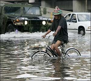 A cyclist navigates floodwaters as the National Guard transports residents to the Superdome after their neighborhoods were flooded by Hurricane Katrina in New Orleans.