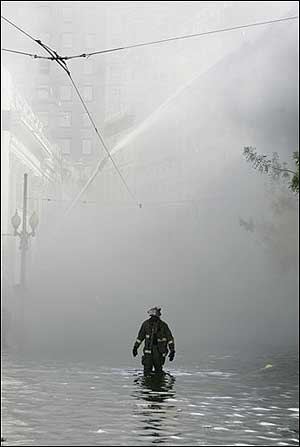 New Orleans firefighters walks through flood water to help battle a building fire in downtown New Orleans, Wednesday, Aug. 31, 2005. Hurricane Katrina left much of the city under water. Officials were uncertain on the cause.