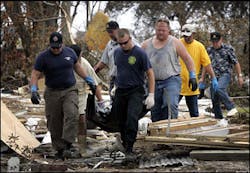 Members of the Mississippi Fire Department, funeral employees and volunteers carry the body of a man who was killed when his home collapsed during Hurricane Katrina in Biloxi, Miss., Thursday, Sept. 1, 2005. The man was found in the rubble of his home.