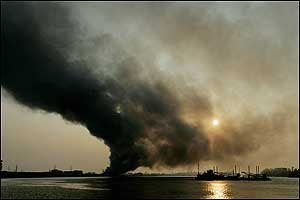 A U.S. Coast Guard vessel heads south on the Mississippi River past a fire on the east side of New Orleans, La., early Friday, Sept. 2, 2005. In the aftermath of Hurricane Katrina, firefighters say they will let the fire burn itself out.