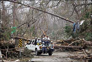 Member of the FEMA Urban Search and Rescue Task Force One team from Virginia make their way through debris from Hurricane Katrina to document corpses in Waveland, Miss.