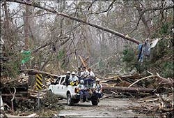 Member of the FEMA Urban Search and Rescue Task Force One team from Virginia make their way through debris from Hurricane Katrina to document corpses in Waveland, Miss.
