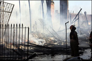 New Orleans firefighter Duaine Daniels helps battle a house fire on the east side of New Orleans, Tuesday, Sept. 6, 2005. Several fires broke out in the downtown area Tuesday.